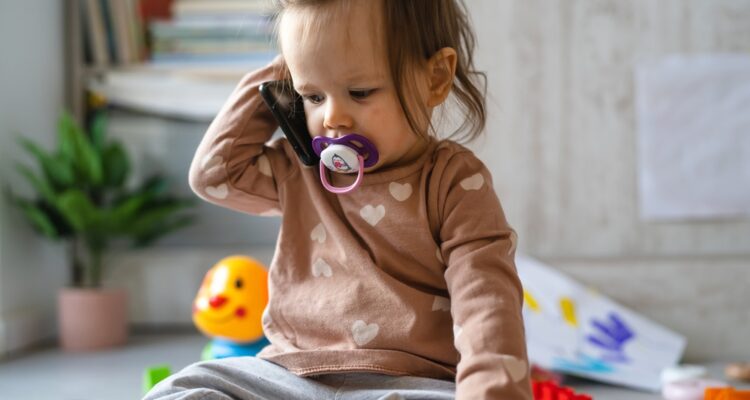 child, using, phone, while, playing, with, toys